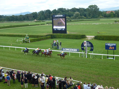 жокей Андраш Штарке и лошадь Danedream пересекают финишную линию Longines Grosser Preis von Baden